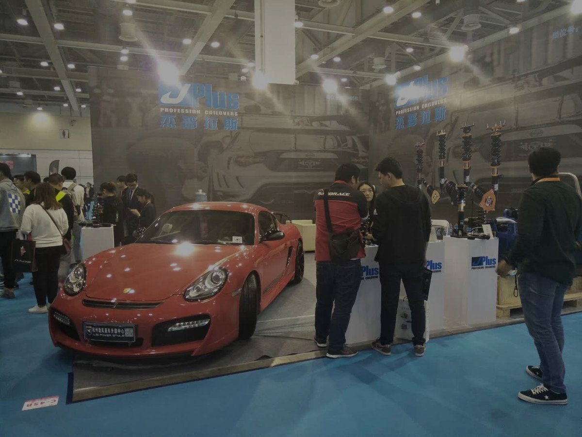J-PLUS booth with a Porsche on display
