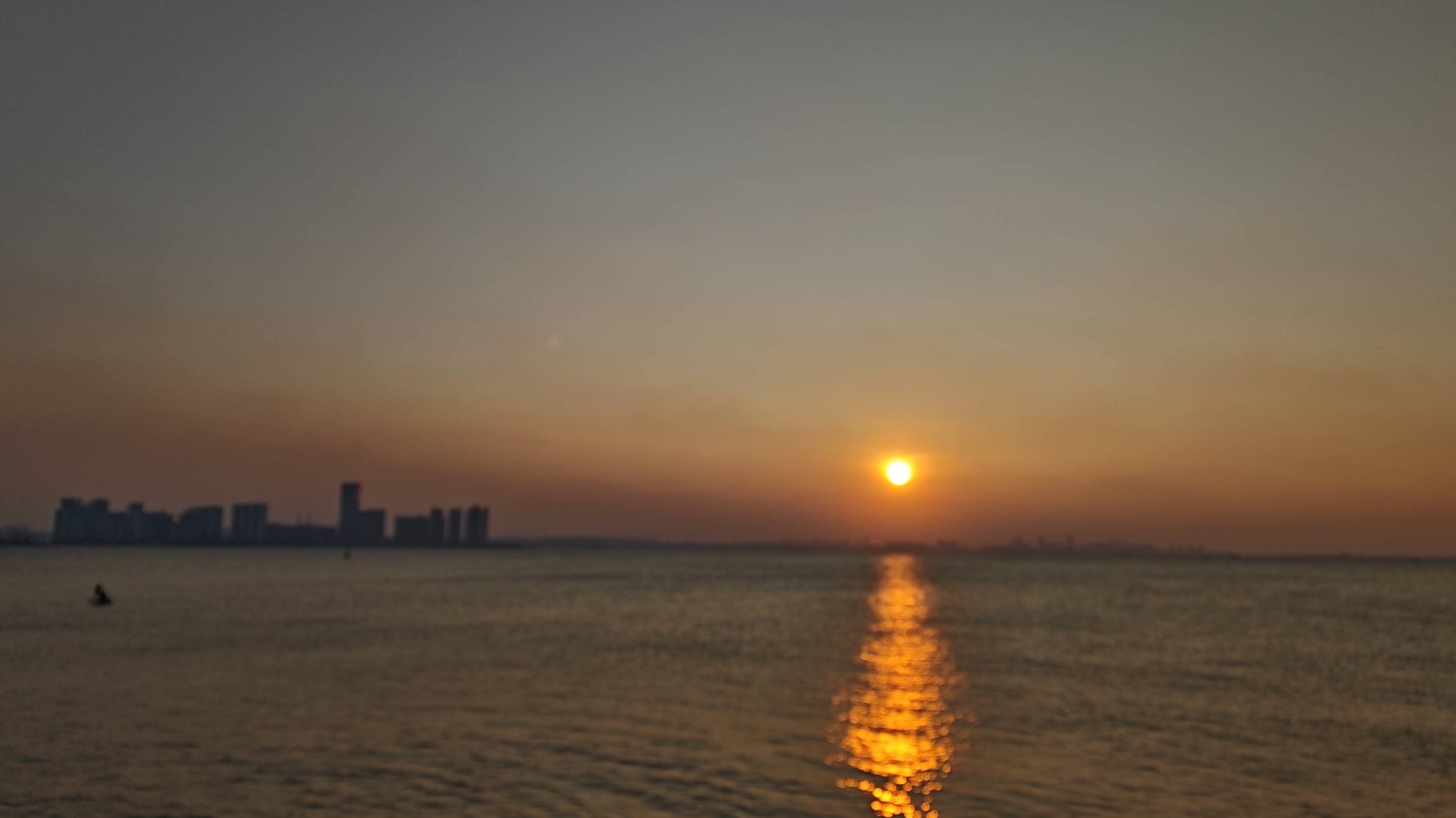 落日与城市剪影 落日沉入海面,城市只剩剪影