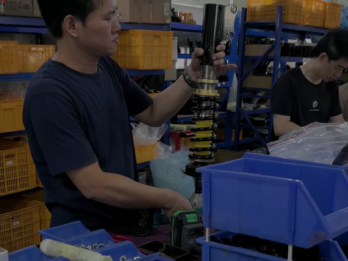 Technician assembling a coilover